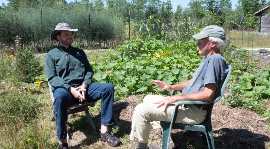 Image of Remi Rice speaking to a farmer in the field.